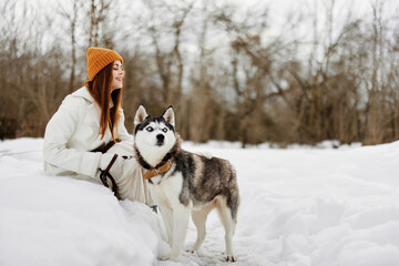 young woman in the snow playing with a dog fun friendship fresh air
