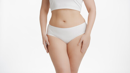 Fototapeta na wymiar Horizontal medium shot of white-skinned plus size woman in white underwear strokes her body on white background | Body care concept