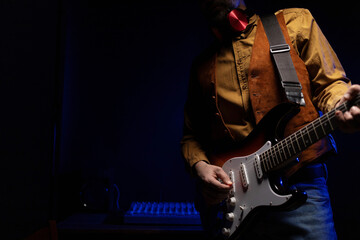 Man playing electric guitar. Musician at record studio holding electric guitar