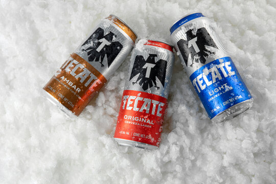 Mexico ,CDMX - April 08, 2022: Top view of tecate beers of three types, original, light and amber on an ice base and copy space
