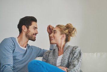 Keeping the art of conversation alive. Shot of a young couple enjoying a conversation on their sofa at home.