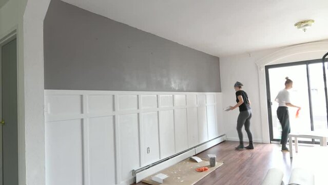 Renovation work in residential premises. People are painting the interior wall in the house