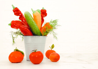 Fototapeta na wymiar Seasonal vegetables and tropical fruits on a marble table near a white brick wall.