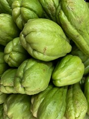 Fototapeta premium Brazilian green chayote. Closeup of various vegetables stacked.