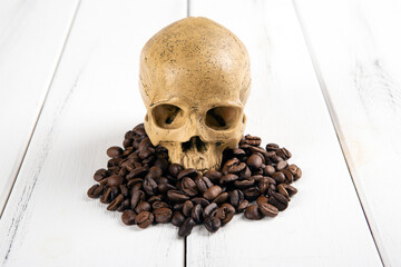 roasted coffee beans with a human skull as a symbol of danger