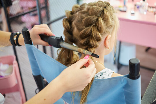 Hairdressing services. Reating hairstyle. Hair styling process. Children hairdressing salon