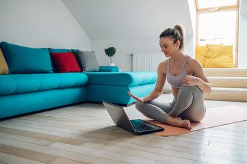 Woman training at home while using a laptop