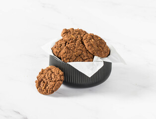 Vegan Chocolate oatmeal cookies with nuts in a serving bowl. White background