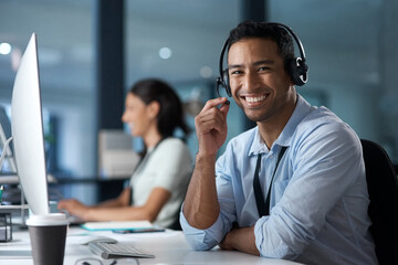 Our customer satisfaction rate says it all. Portrait of a young man using a headset and computer in...