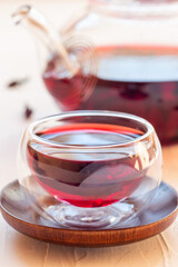 Red tea karkade or hibiscus in glass cup and glass tea pot, vertical, closeup