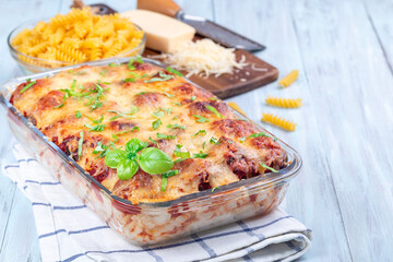 Mac and cheese with meatballs, mozzarella, tomato sauce and basil, in backing dish, horizontal