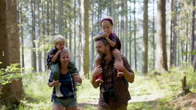Family with small children walking outdoors in summer nature.