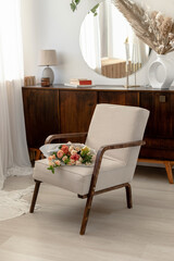 Spring bouquet on retro armchair. nude interior. Dresser and mirror
