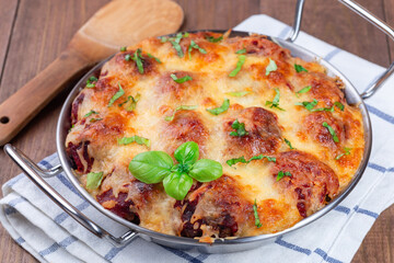 Mac and cheese with meatballs, mozzarella, tomato sauce and basil, in metal backing dish, horizontal