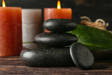 Fototapeta na wymiar Spa stones with aroma candles on wooden table