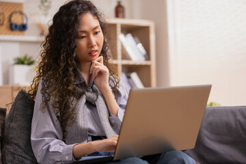 Asian woman designer sitting and thinking about design in the morning at home.