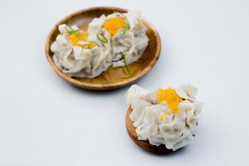 close up of dimsum chinese food. served on a plate with a white background.