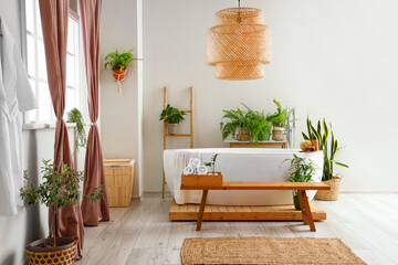 Interior of stylish bathroom with bench and beautiful houseplants
