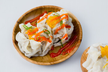 close up of dimsum chinese food. served on a plate with a white background.