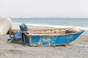 Fototapeta na wymiar 海辺の砂浜に置かれたボート