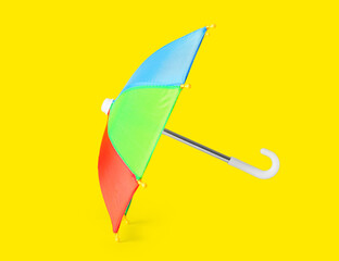 Open umbrella on yellow background