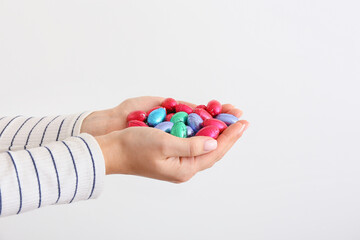 Female hands with chocolate Easter eggs on light background, closeup