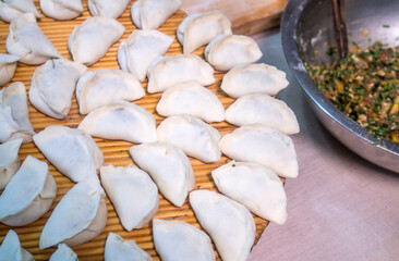 Raw Chinese dumplings on the reed plate ready for steaming