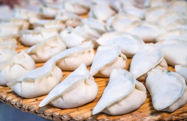 Raw Chinese dumplings on the reed plate ready for steaming