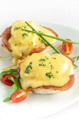 eggs benedict breakfast with ham and hollandaise sauce