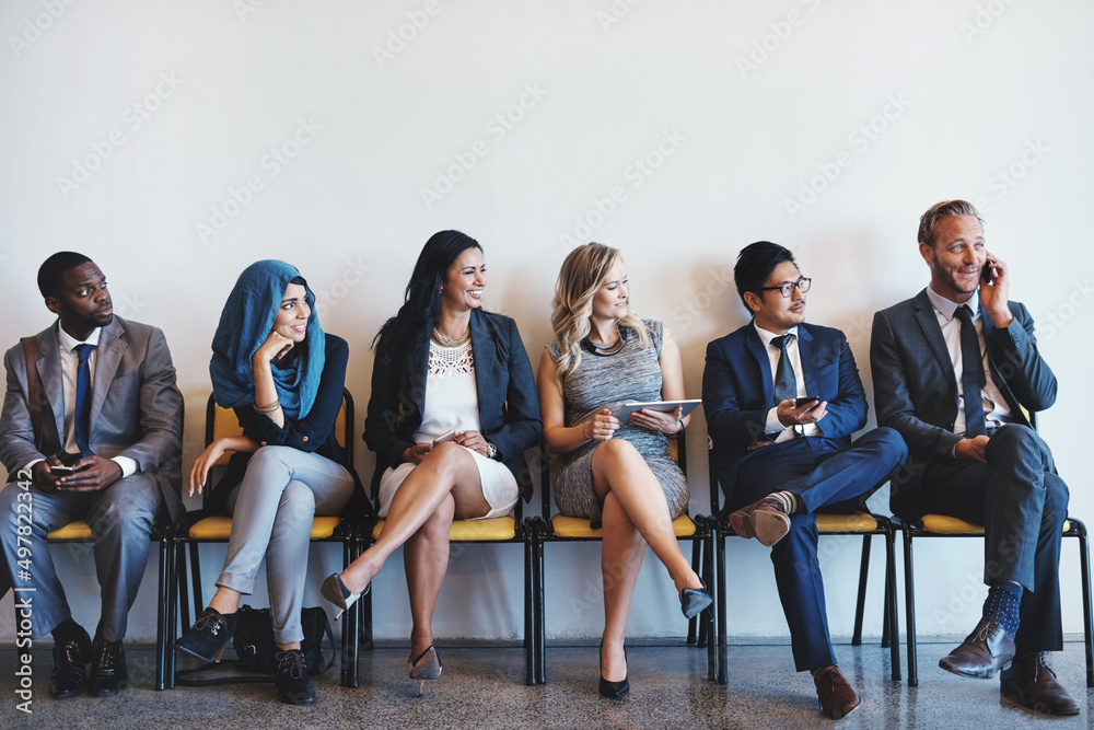Poster we can hear everything youre saying. shot of a group of confident businesspeople waiting in line for