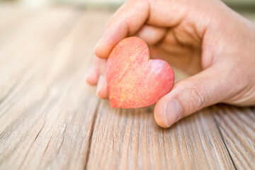 hand holding apple pie with heart shape, concept of love