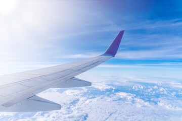 Wing of an airplane cruising above the clouds