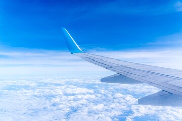 Wing of an airplane cruising above the clouds