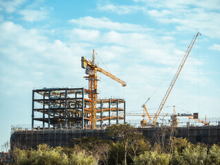 Fototapeta na wymiar Building under construction, cranes and high-rise building