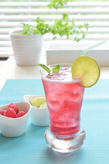 Summer Concept, Cranberry soda with lime, raspberry and mint at the window