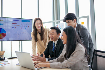 Asian business team male and female colleagues talking at work share ideas  with laptop, Happy colleagues work together on computer in office.