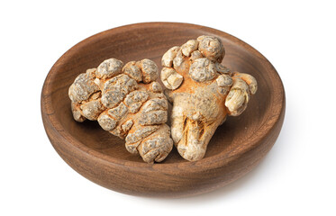 Dried notoginseng roots in the wooden bowl, isolated on the white background.