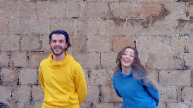 athletic couple dances in perfect synchronization in front of the camera