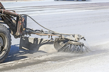Mechanical cleaning of the sidewalk from garbage on a spring day