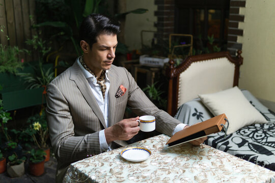 Man in suit choosing a fabric in swatch.