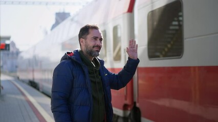 Ukrainian man saying good bye and waving to his family in train leaving Ukraine due to Russian invasion in Ukraine.