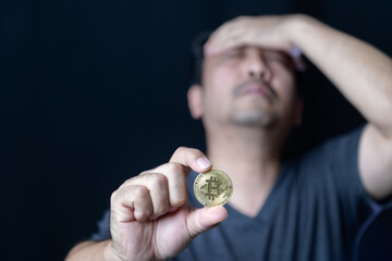 Middle man holding bitcoins and feel stressed because of the loss of online bitcoin trading.