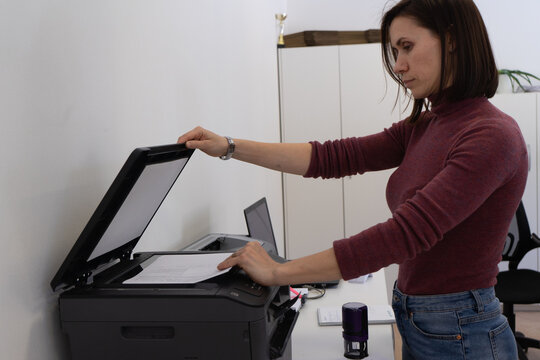 Woman makes a copy, uses a scanner, printer