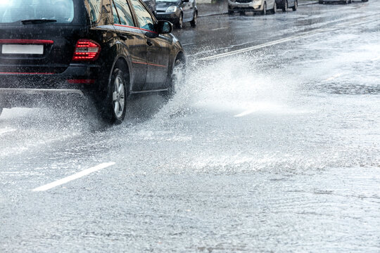 rainwater splashing from car wheels during heavy rain