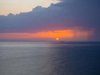 Obraz premium Thunderstorm at sea at dusk. The Beauty of Sunrise waves. Seascape with dramatic cloudy sky and rising sun in Oman. The view from beach