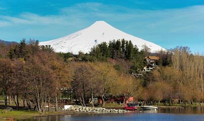 Vulcão Villarrica  em Pucon, sul do Chile , coberto de neve em lago em primeiro plano