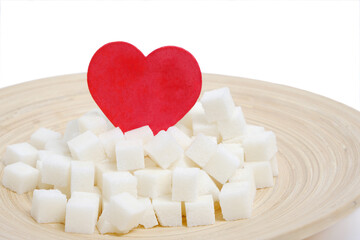 Refined sugar in wooden plate with red heart in middle.Love of sweets.