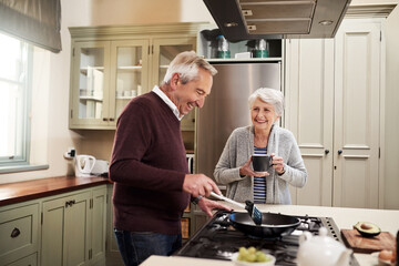 Getting ready to cook her favorite meal. Shot of an affectionate senior couple cooking together in their kitchen at home.