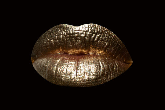 Gold lips. Gold Paint on mouth. Golden lips on woman mouth. Sensual sexy lip. Isolated on black background, clipping path. Glamour background. Lipstick kiss.