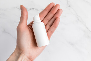 White cosmetic lotion cream serum oil mockup bottle packaging, beauty spa medical skin care, shot in a woman's hand on marble background, collagen healthcare medicine concept